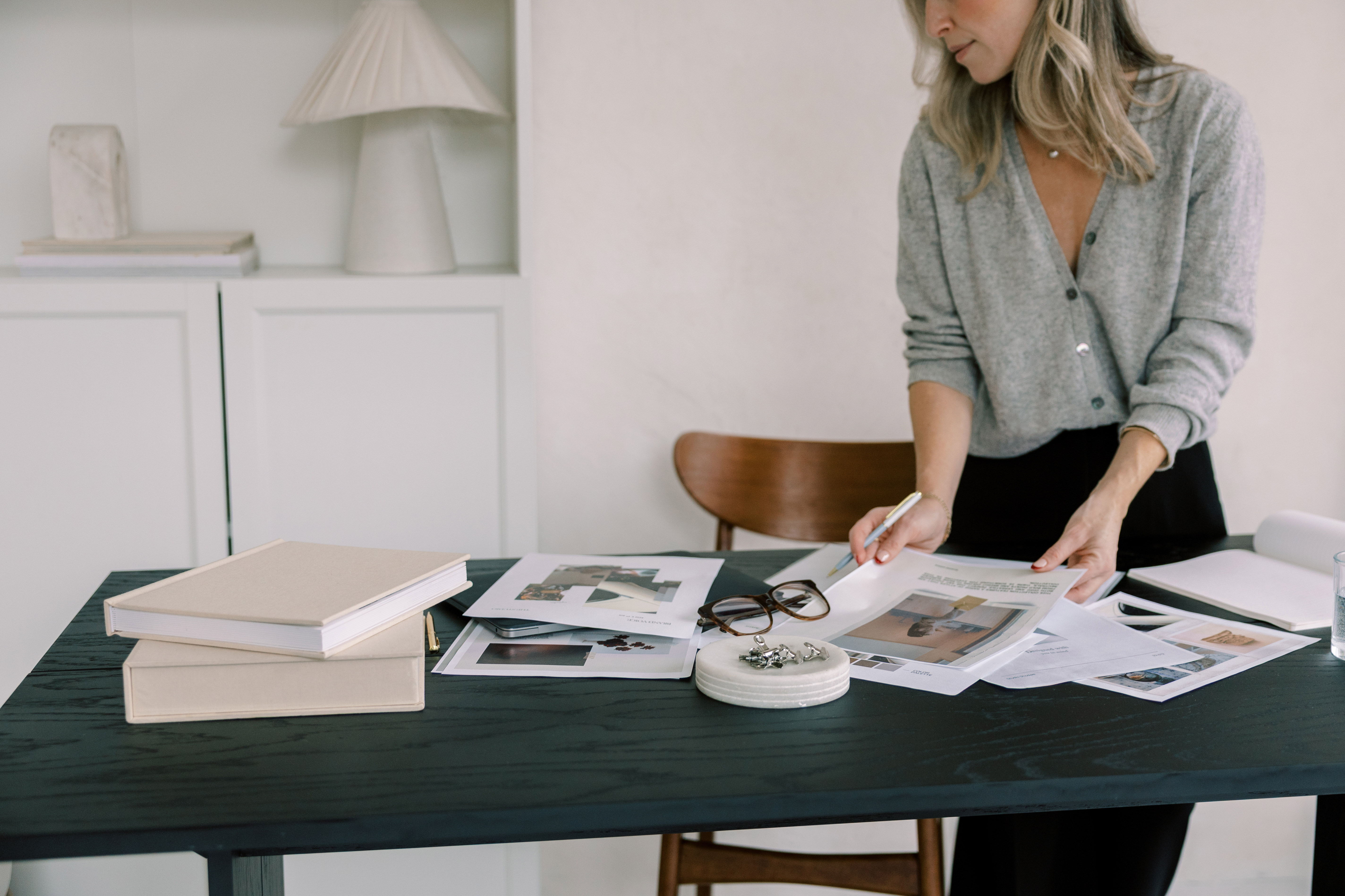 A localization specialist reviewing printed proofs at a studio table
