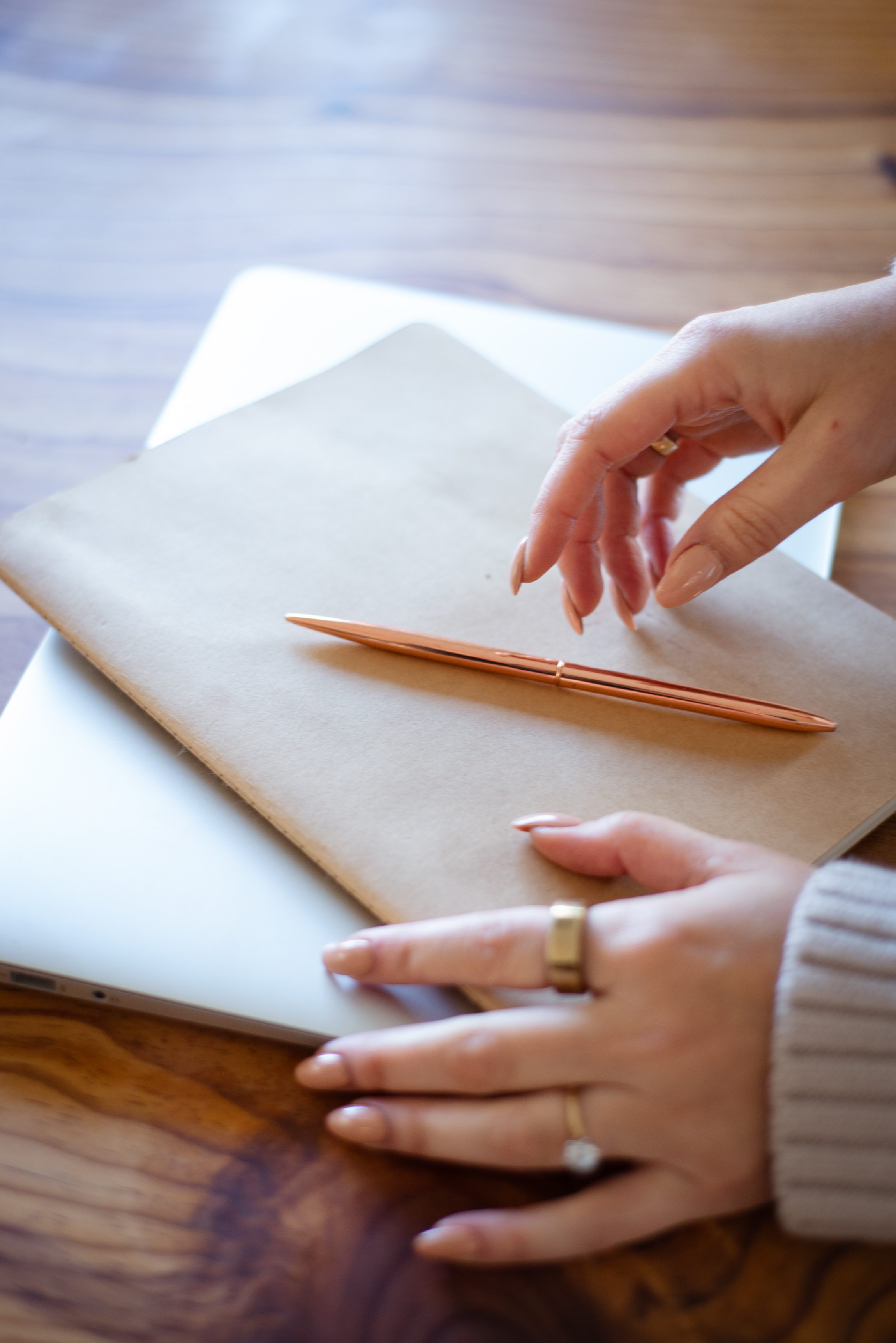 A translator's hands and pen resting on a notebook